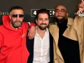 Drei Männer posieren vor einem Banner mit "4 Blocks Staffel 4". Einer trägt eine rote Nike-Jacke, ein anderer einen beigen Trenchcoat.