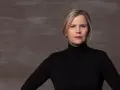 Porträt einer Frau mit blonden Haaren und einem schwarzen Rollkragenpullover. Sie könnte eine Schauspielerin sein, die in **Filme von Michaela Schaffrath** mitspielt.