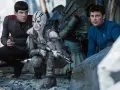 Die Besetzung von Star Trek 2009: Spock, eine Kriegerin mit Kriegsbemalung und Dr. McCoy kauern im Trümmerfeld.