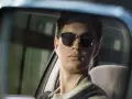 Ein junger Mann mit Sonnenbrille und Kopfhörern im Rückspiegel, der an die Besetzung von Baby Driver erinnert.