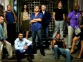 Die Hauptbesetzung von Prison Break posiert auf Treppen vor einem Gittertor.