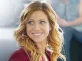 Brittany Snow lächelt in einem roten Blazer. Ein Blick auf ihre Rolle in Filmen von Brittany Snow.