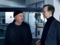 Zwei Männer, ein starkes Team, blicken auf Fahndungsplakate.