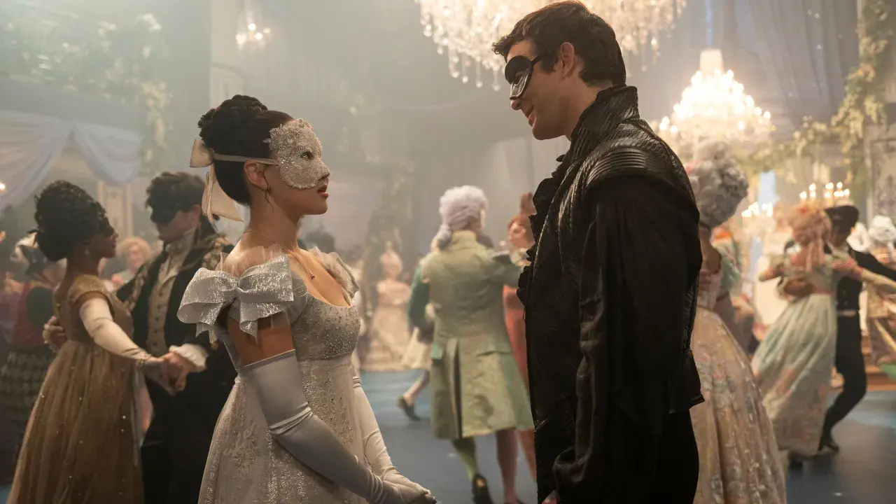 Maskenball-Szene mit einem Paar im Vordergrund, das sich ansieht. Ein Fest für die Augen, wie man es von Bridgerton Staffel 4 erwarten würde.