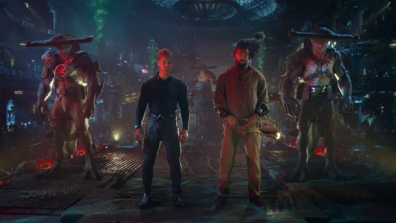 Besetzung von Aquaman: Lost Kingdom: Jason Momoa und Patrick Wilson stehen zwischen zwei Hammerhai-ähnlichen Kreaturen in einer düsteren, futuristischen Umgebung.