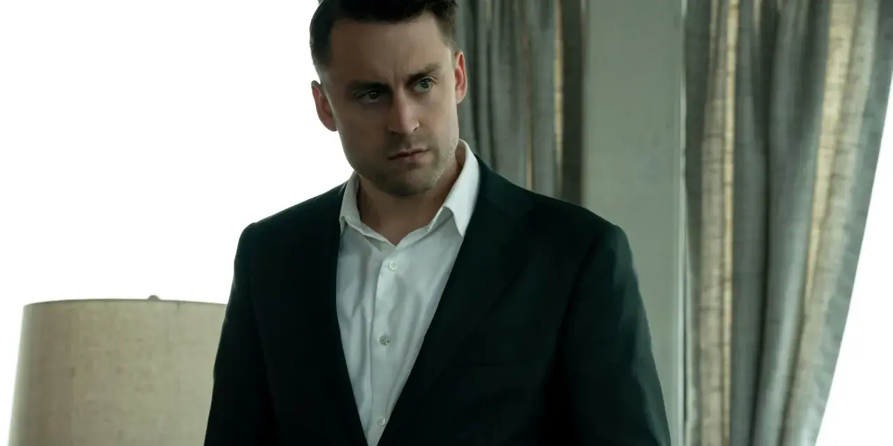 Kieran Culkin als Roman Roy in Succession, ein Mann im Anzug, der nachdenklich in die Ferne blickt.