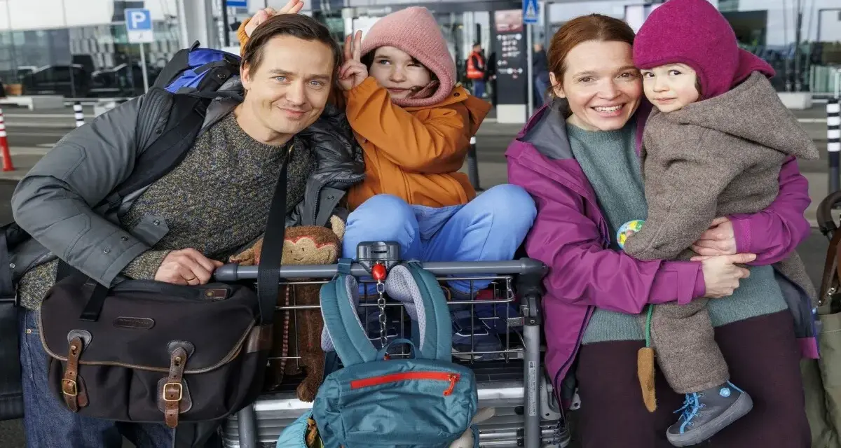 Glückliche Familie am Flughafen, bereit für eine Reise, die sich anfühlt wie eine millionen minuten Vorfreude.