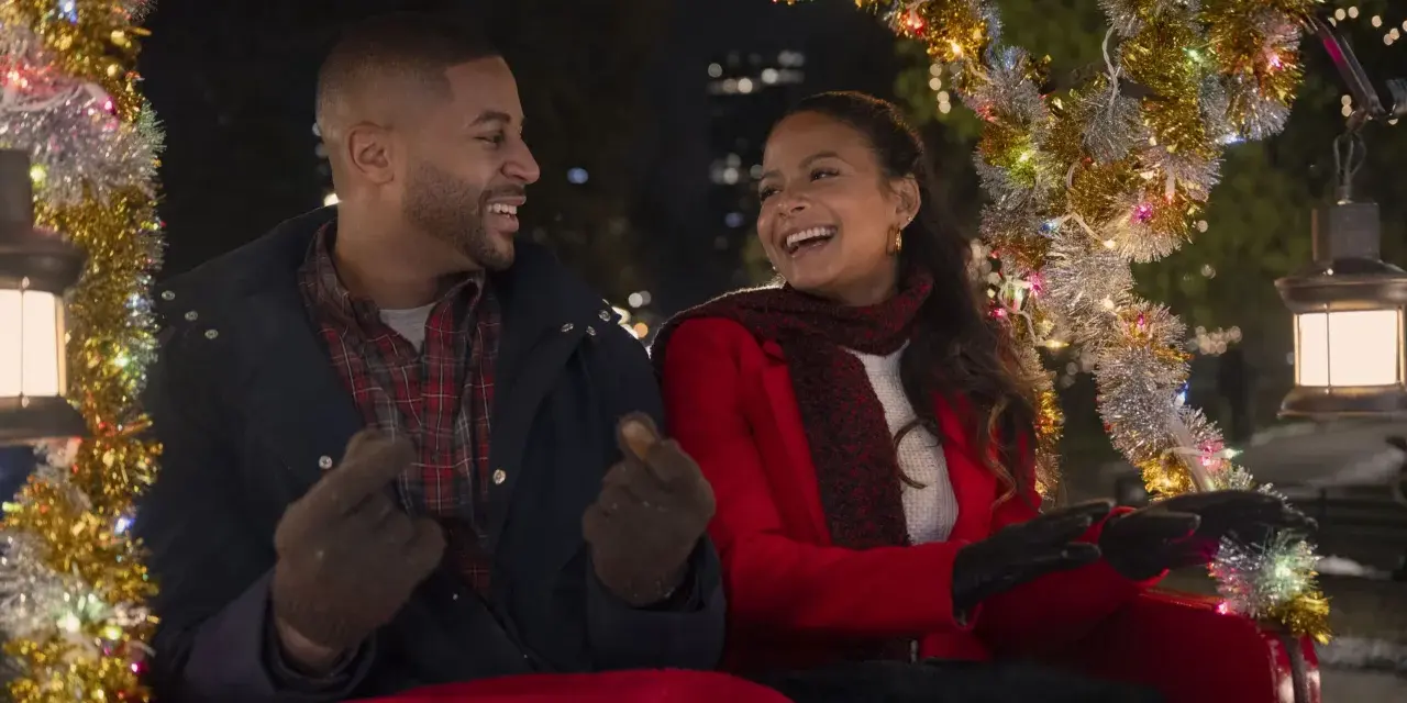 Ein glückliches Paar in einer Kutsche, geschmückt mit Lichterketten. Sie lachen und zeigen aufeinander. Vielleicht ein Versprechen: "Meet me next Christmas.
