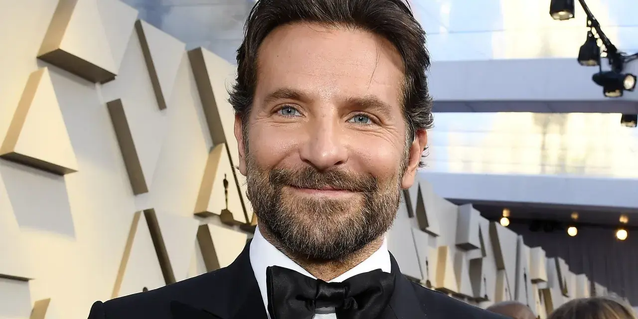 Bradley Cooper, bekannt für seine Rolle in Filmen wie "A Star Is Born", lächelt in die Kamera.