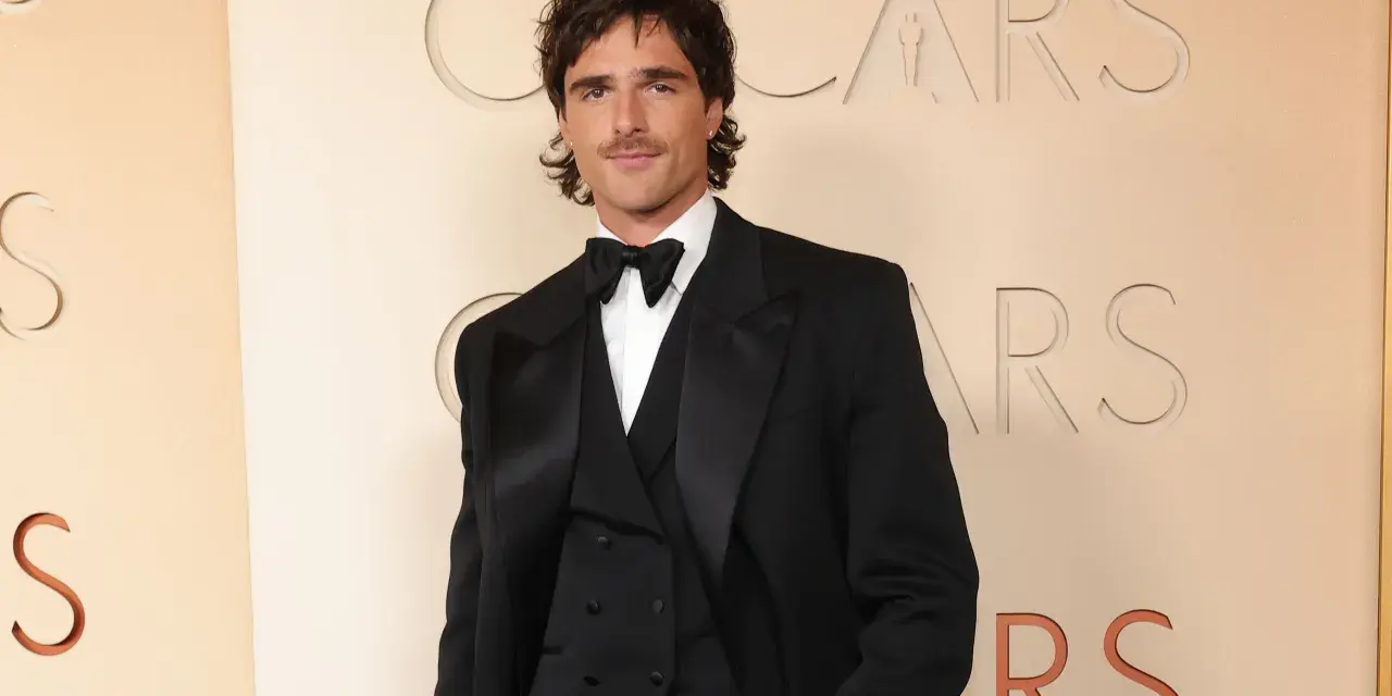 Jacob Elordi in einem schwarzen Smoking vor dem Oscars-Logo. Seine Filme und Serien sind ein Muss für Fans.