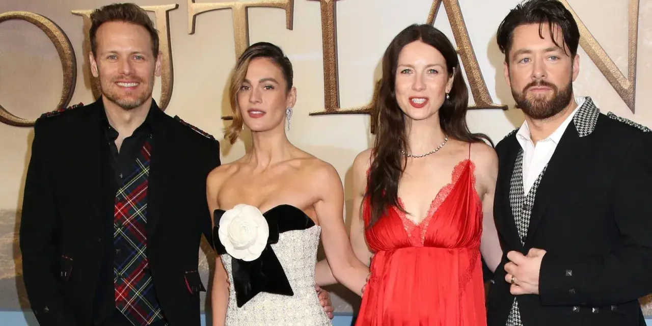 Die Besetzung von Outlander: Sam Heughan, Caitriona Balfe und Richard Rankin posieren lächelnd.