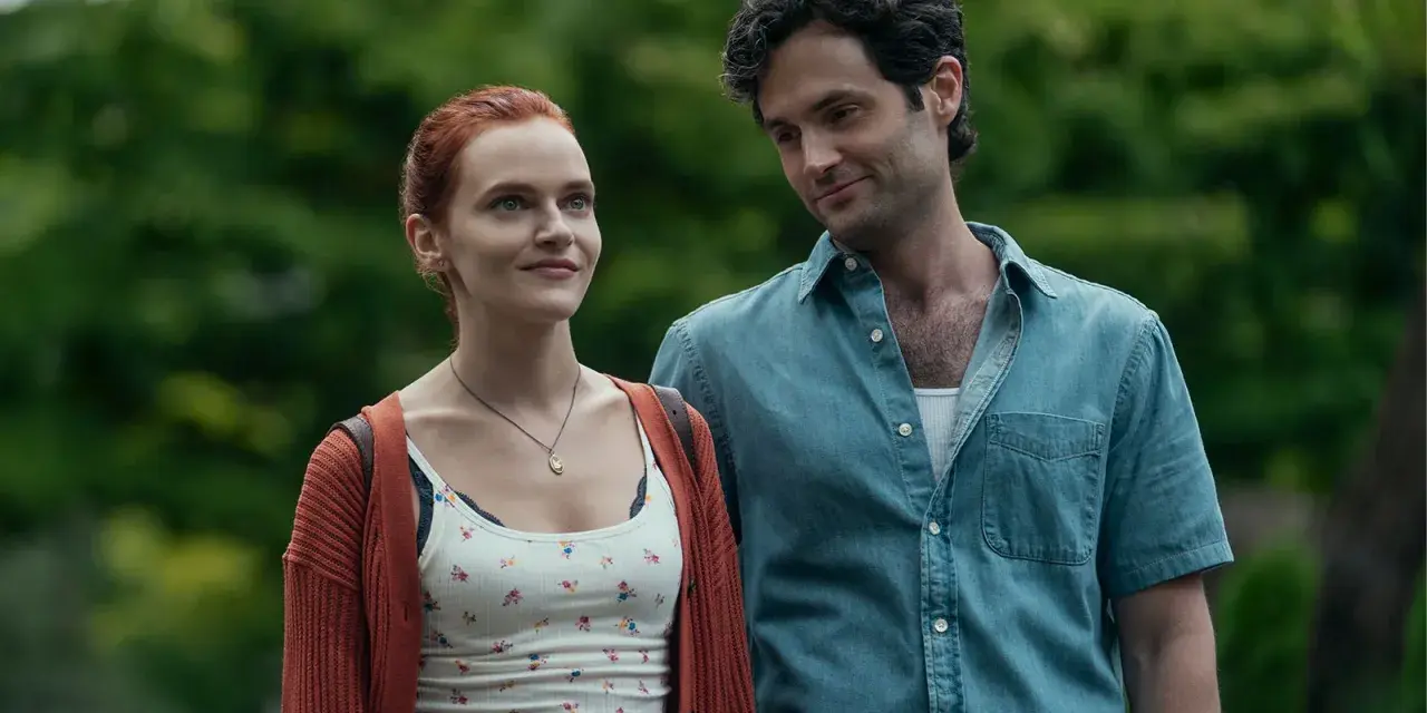 Joe und Kate in **You Staffel 5**. Ein Mann mit dunklen Haaren blickt lächelnd auf eine Frau mit roten Haaren, die ihn ansieht.