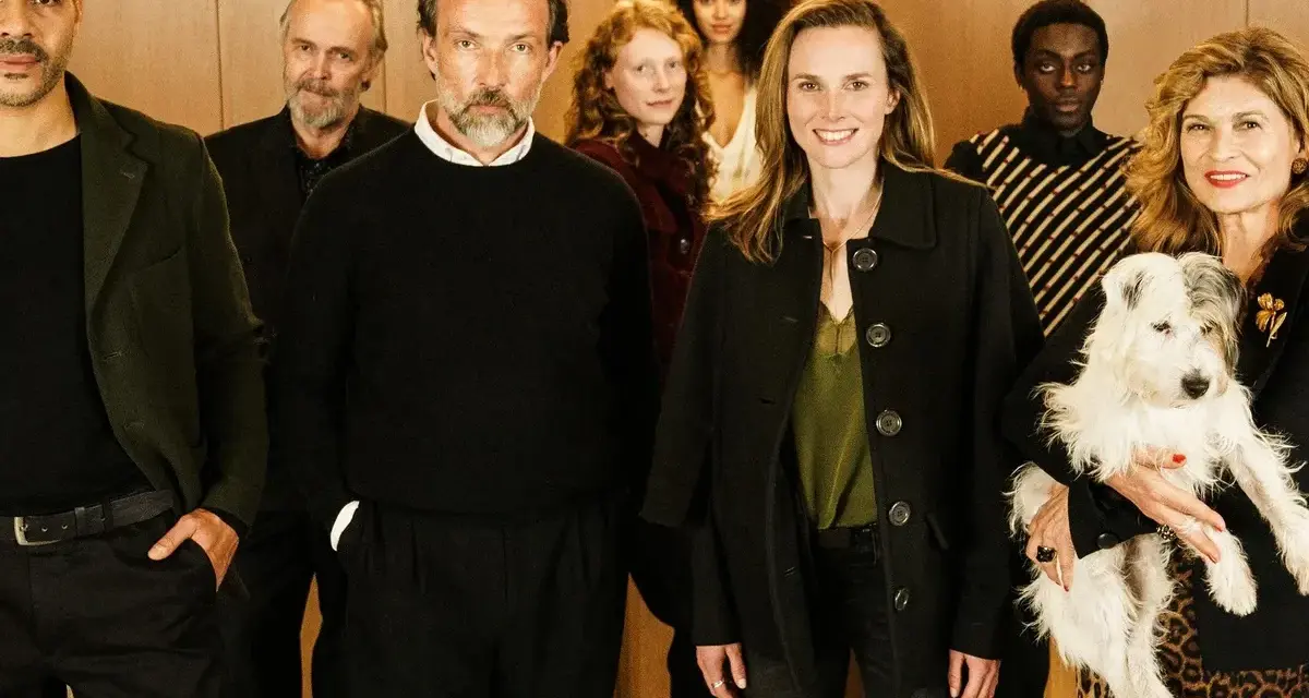 Ensemble der Fernsehserie "Besetzung von Berlin" posiert lächelnd mit einem Hund.