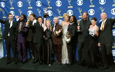 Die Besetzung von Lost feiert Emmy-Erfolge. Die Schauspieler posieren mit ihren Trophäen vor einem blauen Banner mit dem CBS-Logo.