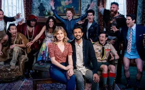 Die Hauptdarsteller von Ghosts Staffel 3 posieren ausgelassen in einem viktorianischen Salon.