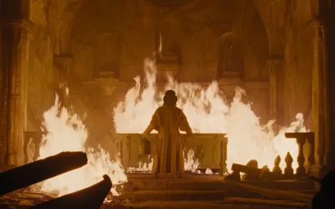 Nosferatu – der untote, steht in Flammen. Ein alter Sarg brennt, während er sich dem Feuer zuwendet.