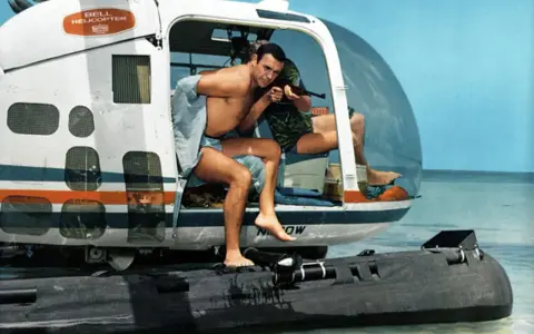 Sean Connery als James Bond 007 in "Feuerball" steigt aus einem Helikopter auf ein Schlauchboot.