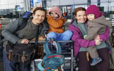 Glückliche Familie am Flughafen, bereit für eine Reise, die sich anfühlt wie eine millionen minuten Vorfreude.