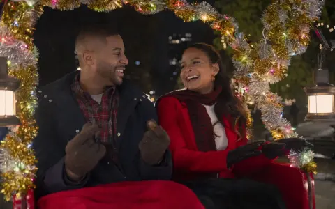 Ein glückliches Paar in einer Kutsche, geschmückt mit Lichterketten. Sie lachen und zeigen aufeinander. Vielleicht ein Versprechen: "Meet me next Christmas.