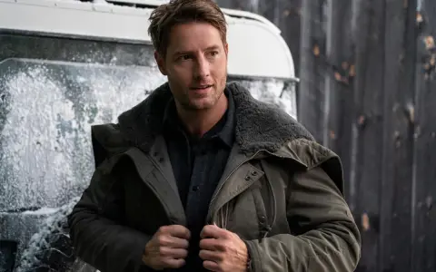 Mann in Winterjacke, inspiriert von "The Noel Diary", steht vor einer verschneiten Kulisse.
