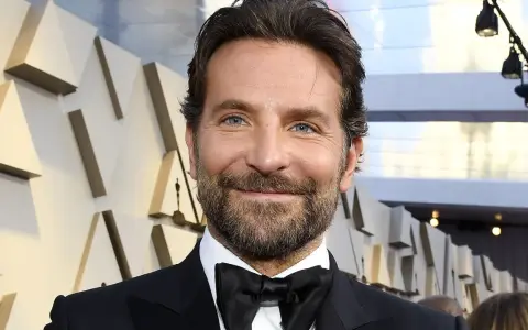 Bradley Cooper, bekannt für seine Rolle in Filmen wie "A Star Is Born", lächelt in die Kamera.