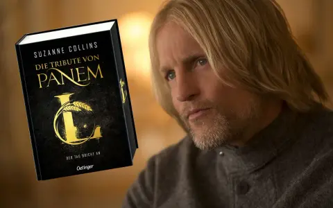 Ein Mann mit langen blonden Haaren und Bart, der an die Besetzung von "Die Tribute von Panem" erinnert, blickt nachdenklich auf das Buch "Die Tribute von Panem".