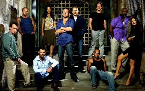 Die Hauptbesetzung von Prison Break posiert auf Treppen vor einem Gittertor.