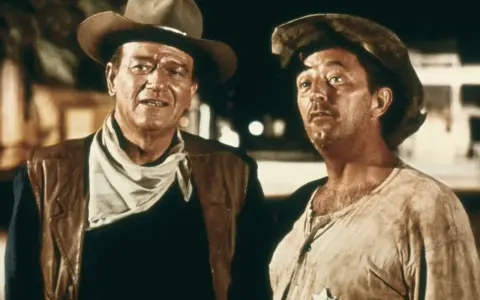 John Wayne und Robert Mitchum in "El Dorado" (1966), zwei raue Cowboys im staubigen Westen, bereit für jedes Abenteuer.