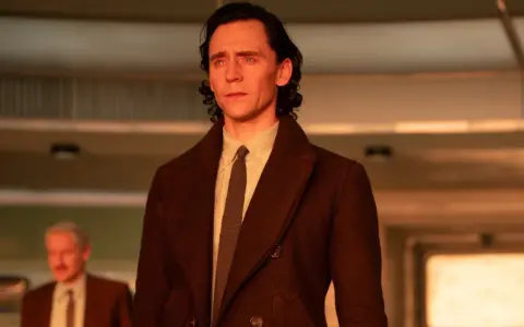 Loki, in seinem braunen Mantel, blickt nachdenklich. Die Hoffnung auf Loki Staffel 3 lebt!