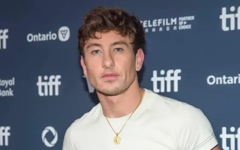Barry Keoghan, bekannt für seine Rollen in Filmen wie "The Banshees of Inisherin", posiert vor dem TIFF-Logo.
