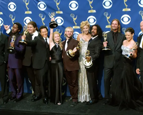 Die Besetzung von Lost feiert Emmy-Erfolge. Die Schauspieler posieren mit ihren Trophäen vor einem blauen Banner mit dem CBS-Logo.