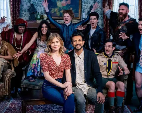 Die Hauptdarsteller von Ghosts Staffel 3 posieren ausgelassen in einem viktorianischen Salon.