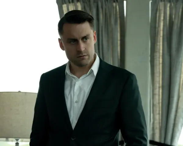 Kieran Culkin als Roman Roy in Succession, ein Mann im Anzug, der nachdenklich in die Ferne blickt.