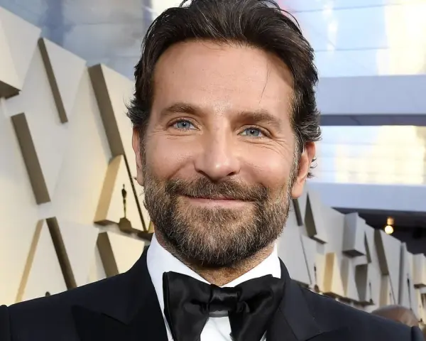 Bradley Cooper, bekannt für seine Rolle in Filmen wie "A Star Is Born", lächelt in die Kamera.