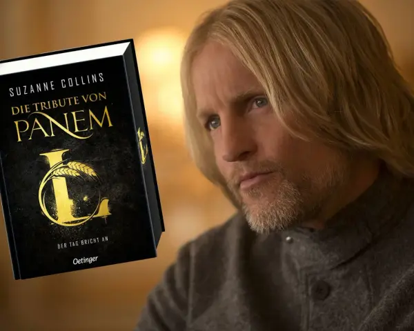 Ein Mann mit langen blonden Haaren und Bart, der an die Besetzung von "Die Tribute von Panem" erinnert, blickt nachdenklich auf das Buch "Die Tribute von Panem".