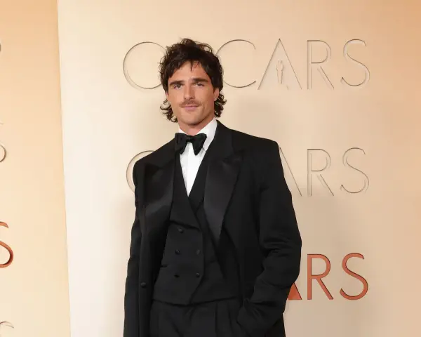 Jacob Elordi in einem schwarzen Smoking vor dem Oscars-Logo. Seine Filme und Serien sind ein Muss für Fans.
