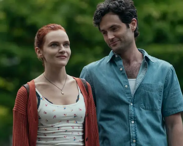 Joe und Kate in **You Staffel 5**. Ein Mann mit dunklen Haaren blickt lächelnd auf eine Frau mit roten Haaren, die ihn ansieht.