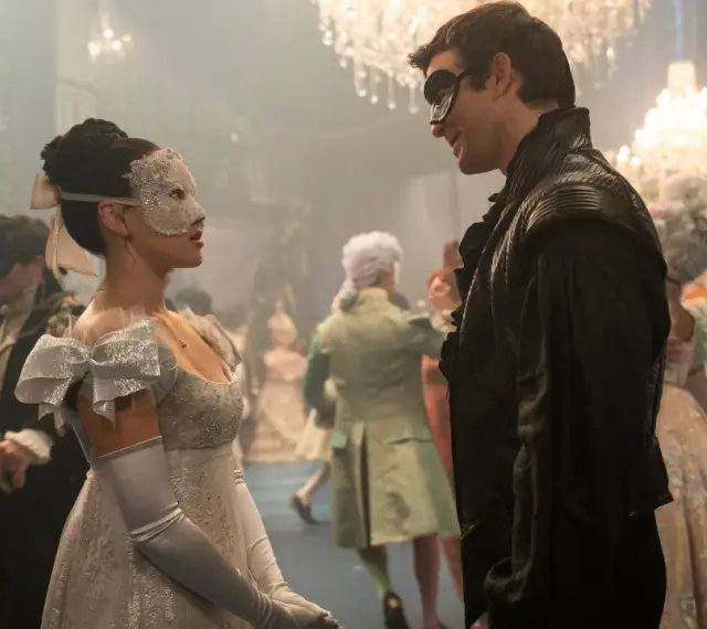 Maskenball-Szene mit einem Paar im Vordergrund, das sich ansieht. Ein Fest für die Augen, wie man es von Bridgerton Staffel 4 erwarten würde.