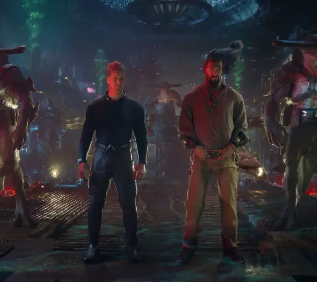 Besetzung von Aquaman: Lost Kingdom: Jason Momoa und Patrick Wilson stehen zwischen zwei Hammerhai-ähnlichen Kreaturen in einer düsteren, futuristischen Umgebung.