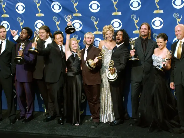 Die Besetzung von Lost feiert Emmy-Erfolge. Die Schauspieler posieren mit ihren Trophäen vor einem blauen Banner mit dem CBS-Logo.