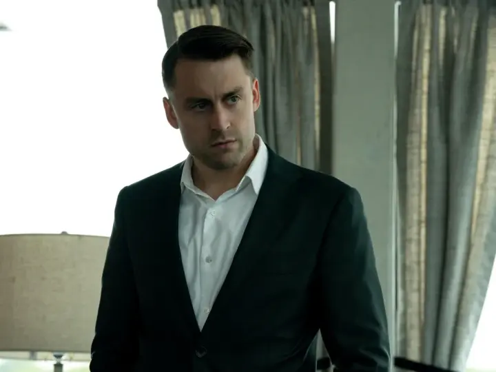 Kieran Culkin als Roman Roy in Succession, ein Mann im Anzug, der nachdenklich in die Ferne blickt.