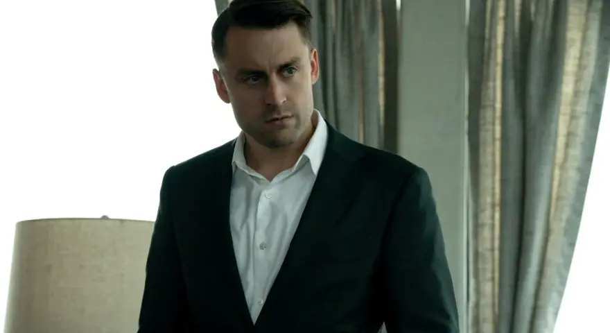 Kieran Culkin als Roman Roy in Succession, ein Mann im Anzug, der nachdenklich in die Ferne blickt.