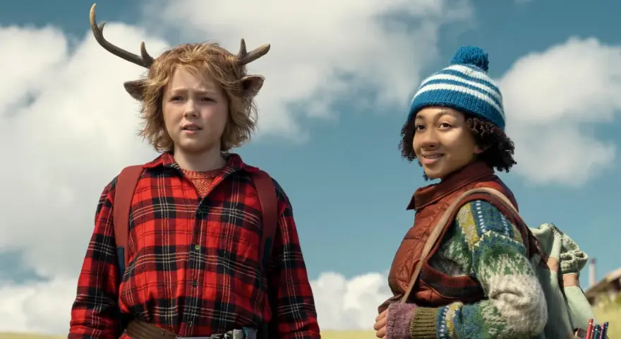 Die Hauptdarsteller der Serie "Sweet Tooth" stehen im Freien. Ein Junge mit Hirschgeweih und ein Mädchen mit Mütze.