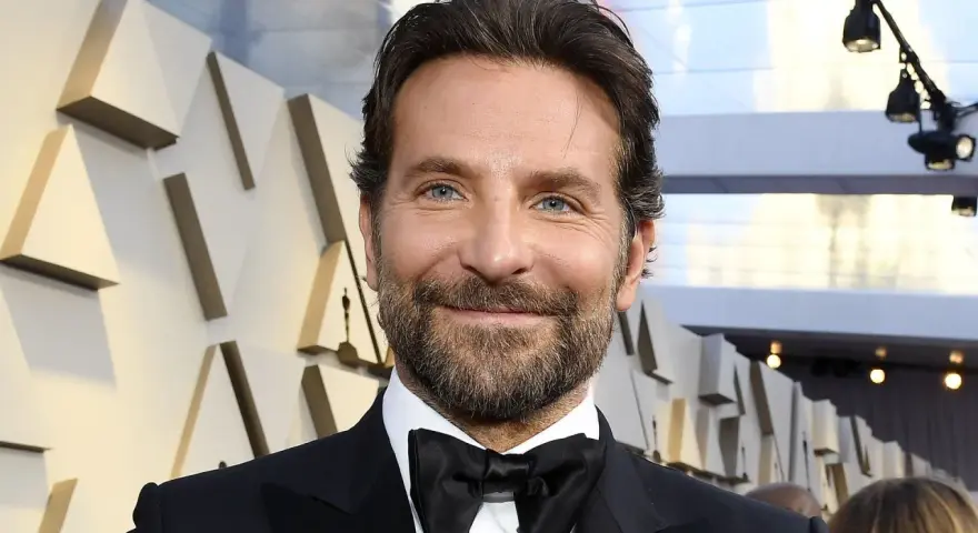 Bradley Cooper, bekannt für seine Rolle in Filmen wie "A Star Is Born", lächelt in die Kamera.
