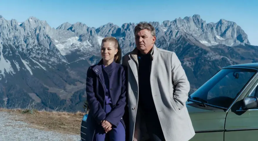 Ein Mann und eine Frau stehen vor einer Bergkulisse. Sie sind Teil von "Der Bergdoktor" Staffel 19 Folge 8.