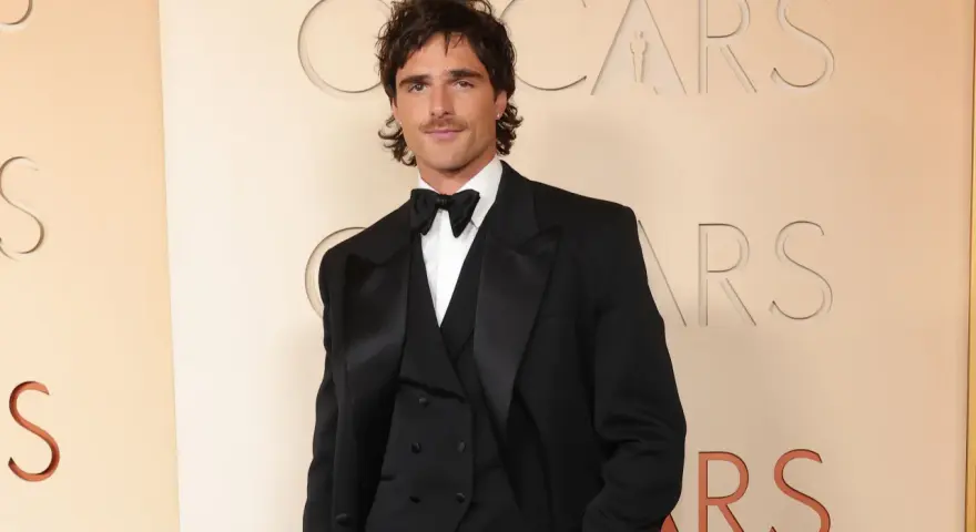 Jacob Elordi in einem schwarzen Smoking vor dem Oscars-Logo. Seine Filme und Serien sind ein Muss für Fans.