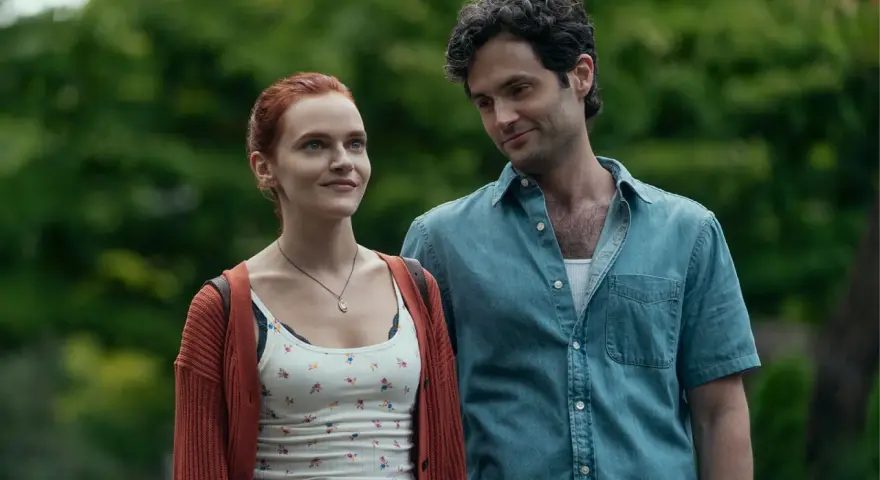 Joe und Kate in **You Staffel 5**. Ein Mann mit dunklen Haaren blickt lächelnd auf eine Frau mit roten Haaren, die ihn ansieht.