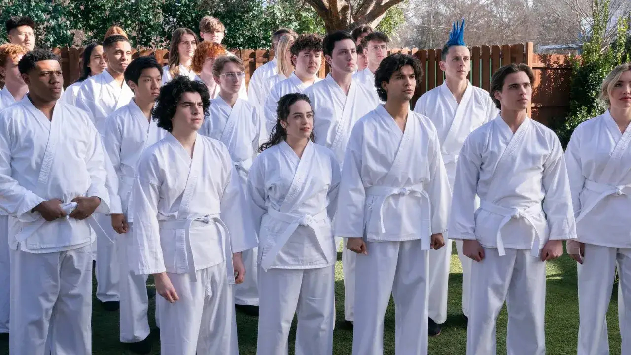 Die Besetzung von Cobra Kai in weißen Karate-Gi, bereit für das Training.