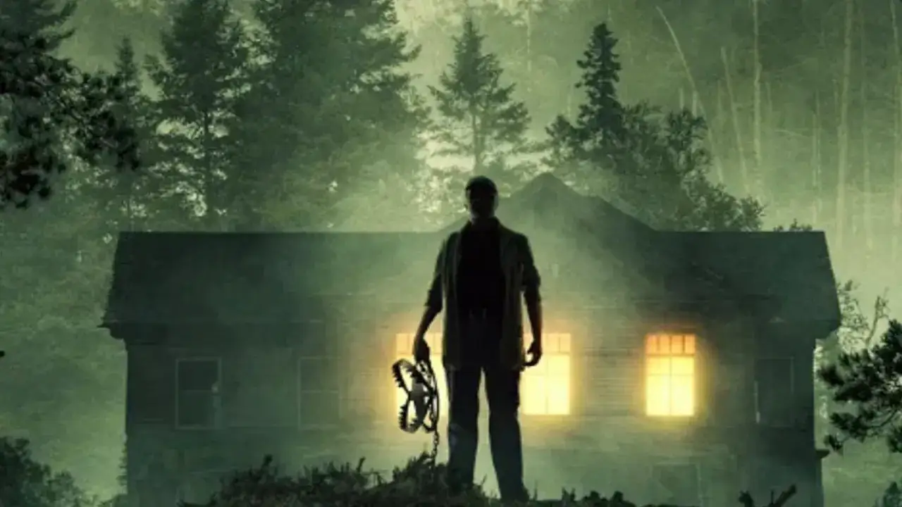 Ein Mann mit einer Bärenfalle steht vor einer dunklen Hütte im Wald. Ein unheilvoller knock at the cabin kündigt sich an.