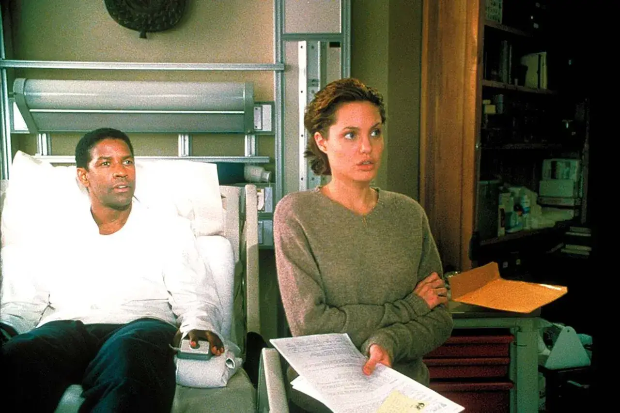 Denzel Washington im Krankenhausbett, Angelina Jolie mit Dokumenten. Die besetzung von die Spur der Knochen in einer Szene.